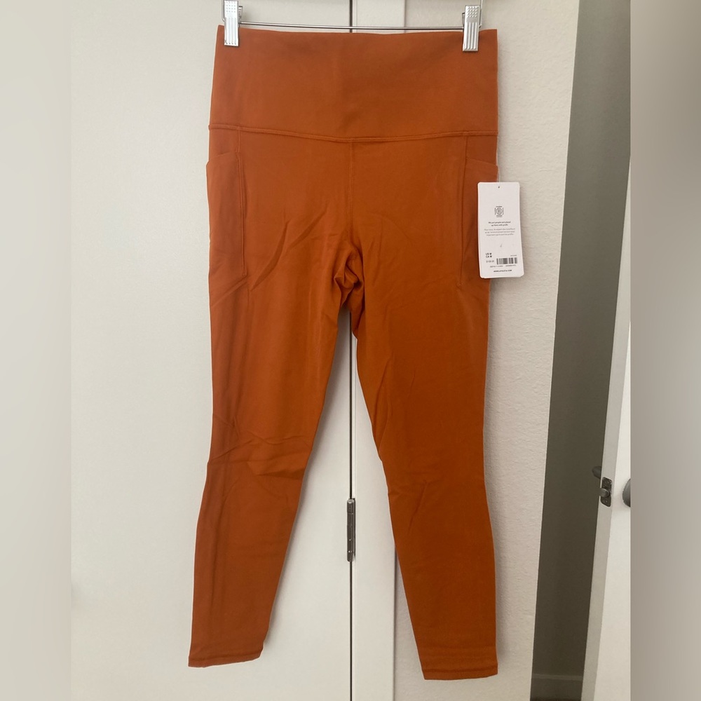 Athleta Salutation Stash in orange. NWT